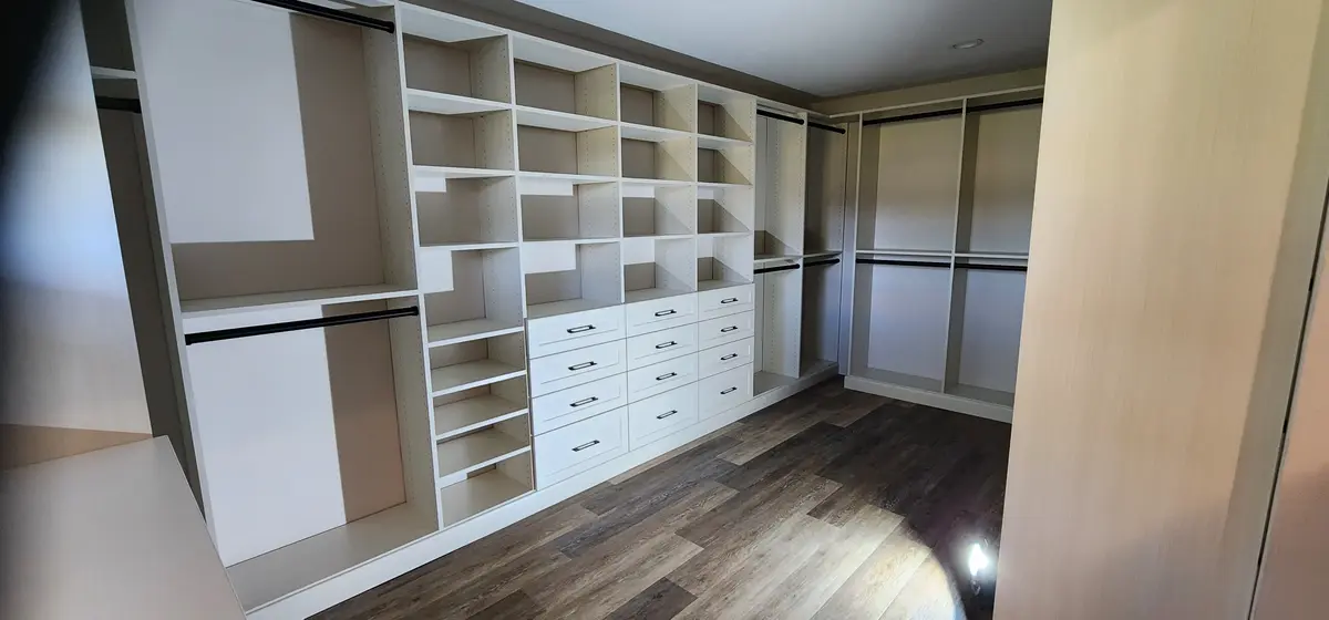 Installed walk-in closet system with hanging rails and shoe shelving