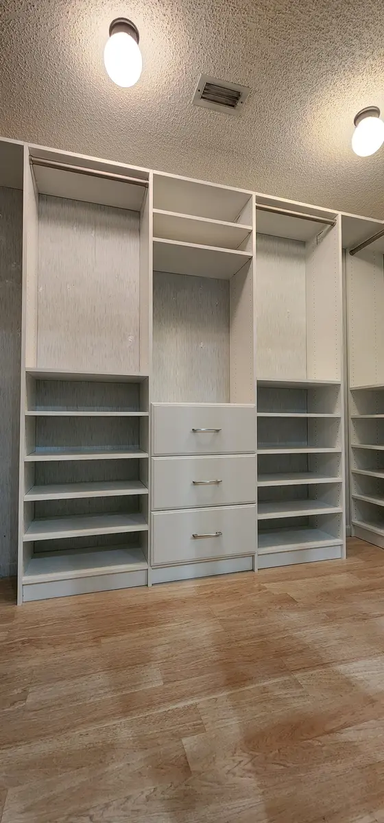 Installed walk-in closet system with hanging rails and shoe shelving