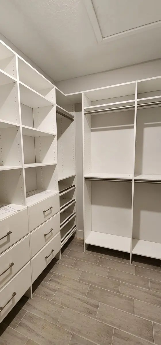 Installed walk-in closet system with hanging rails and shoe shelving