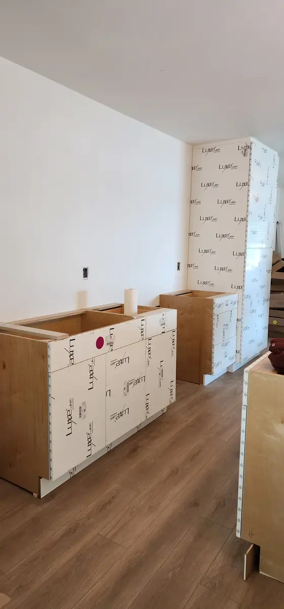 Cabinet work in progress in an unfinished unit with floors protected