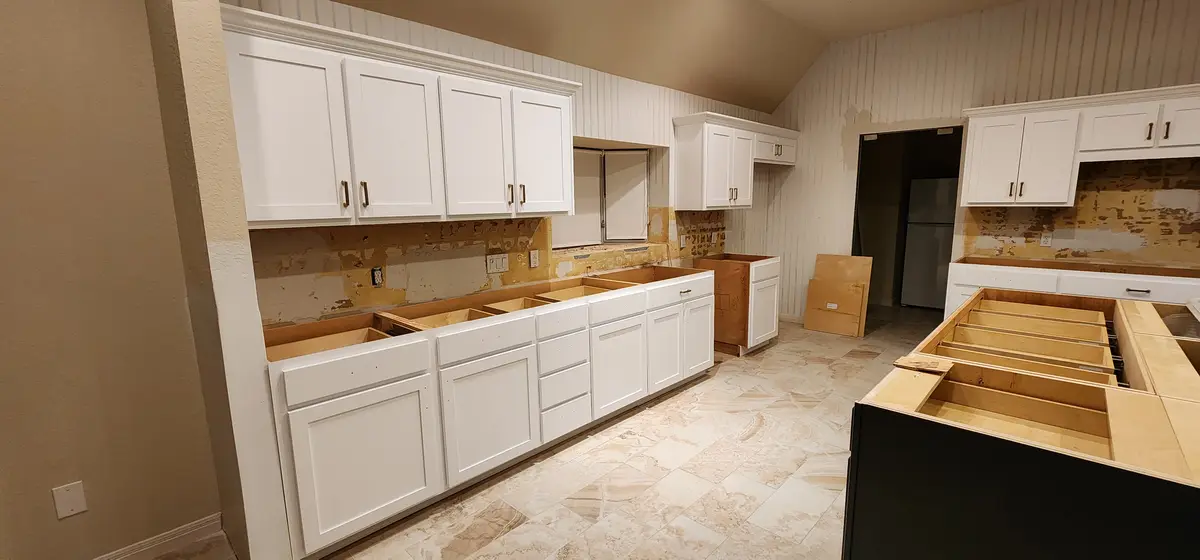 Cabinet work in progress in an unfinished unit with floors protected