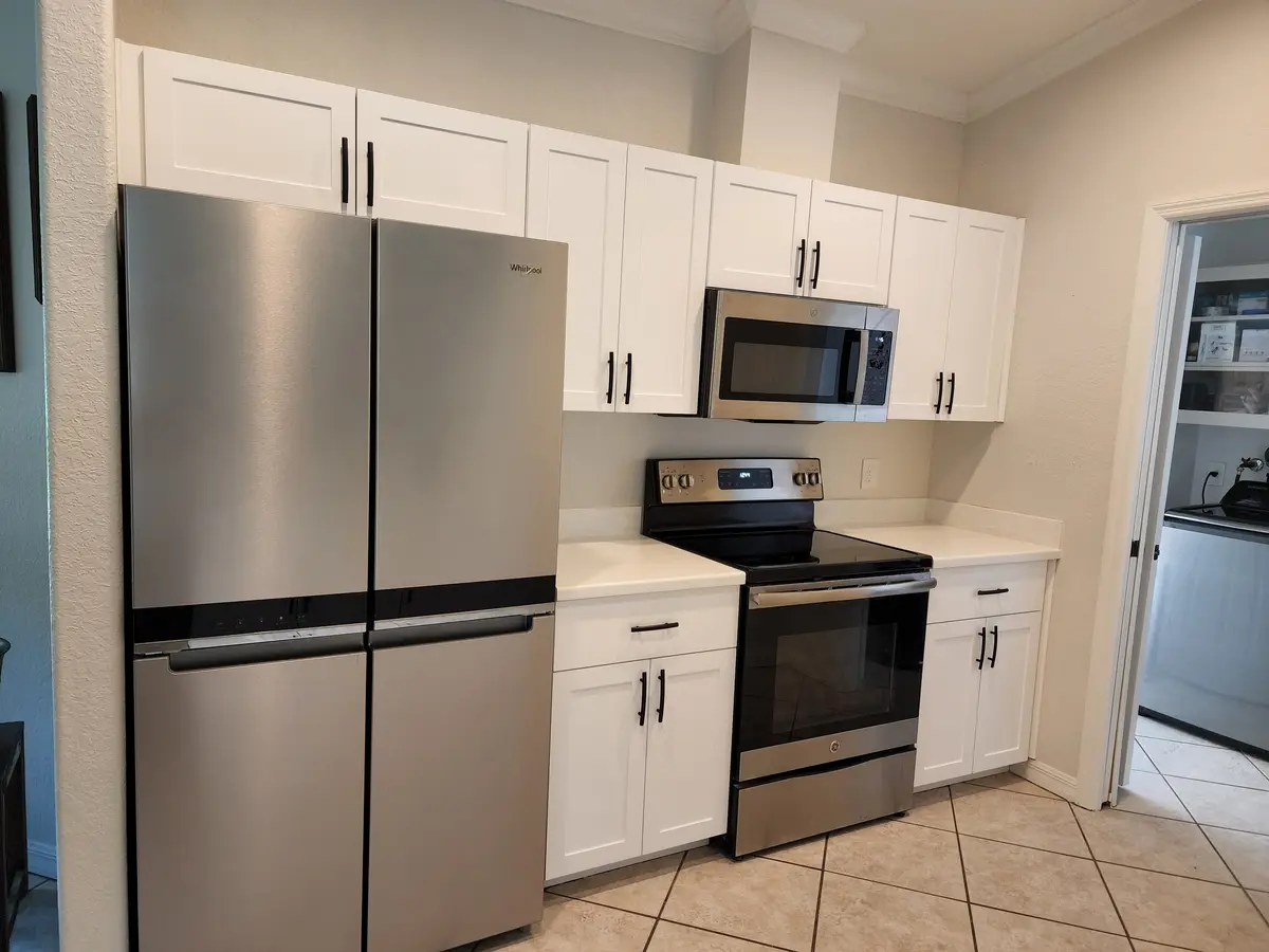 Installed kitchen cabinets with upper and base runs and a tile backsplash