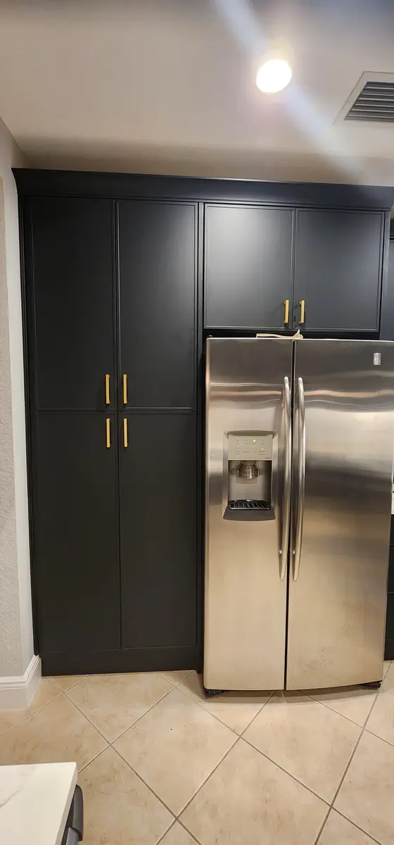 Installed kitchen cabinetry with a tall pantry run and wall oven surround