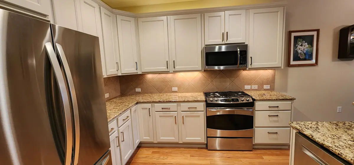 Installed kitchen cabinetry with a tall pantry run and wall oven surround