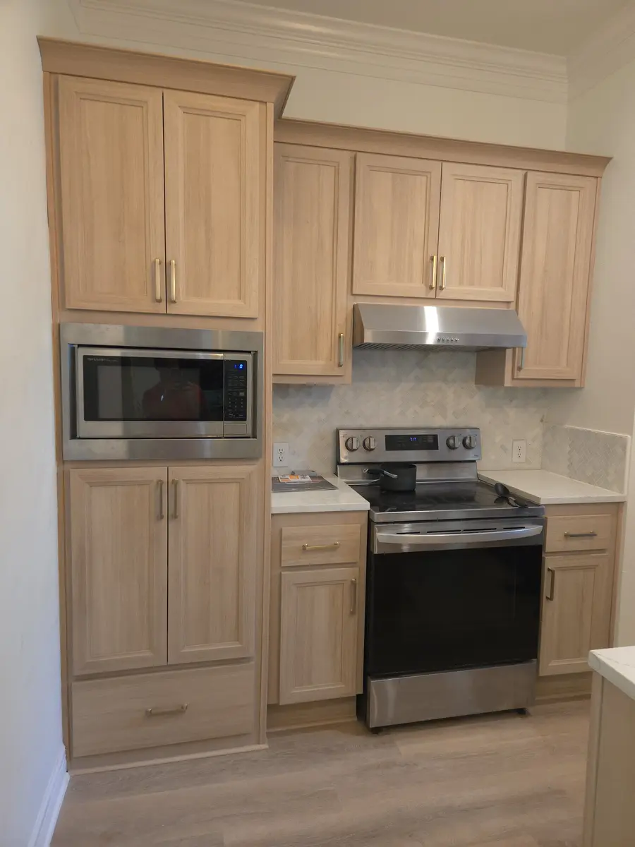 Installed kitchen cabinetry with a tall pantry run and wall oven surround