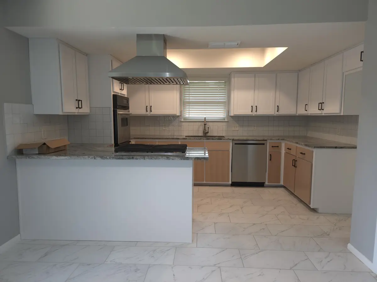 Installed kitchen cabinetry with a tall pantry run and wall oven surround