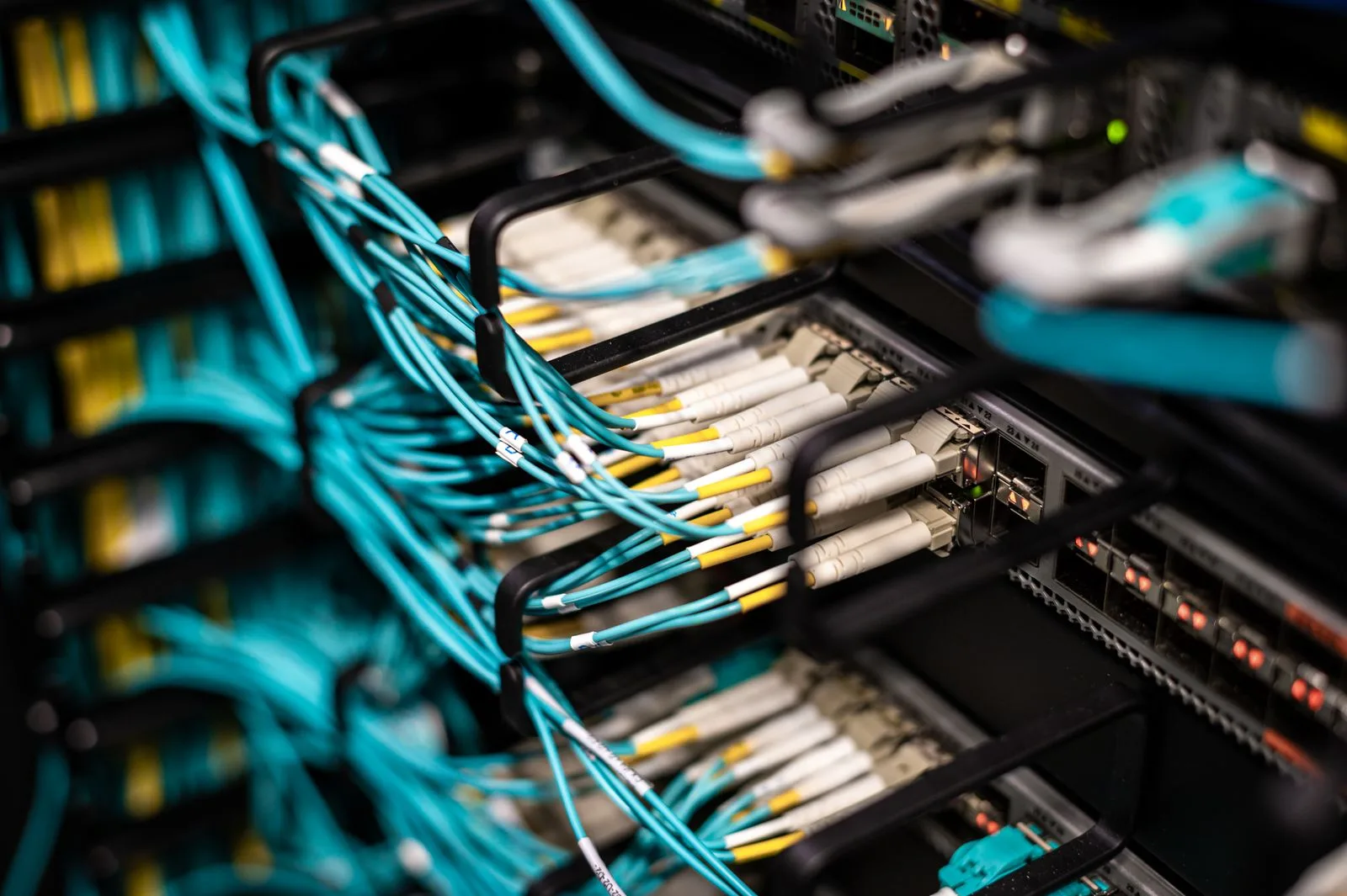Close view of teal and yellow fiber patch cables connected to a patch panel