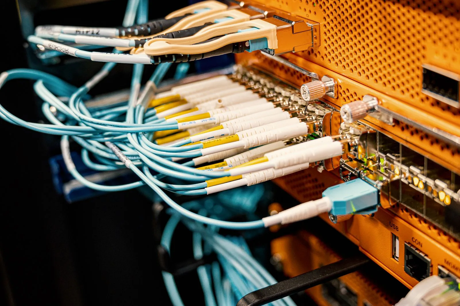 Close view of teal and yellow fiber patch cables connected to a structured cabling panel